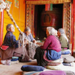 A group of older Tibetan women were busy mending a pull rope for a beautiful giant bell. They all had a smile for us.